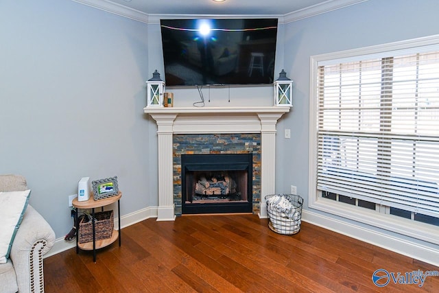 living area with a fireplace, wood finished floors, baseboards, and ornamental molding