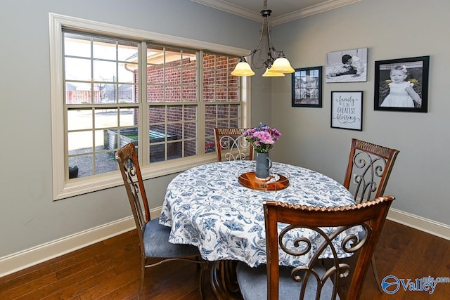 dining room featuring dark wood finished floors, baseboards, and ornamental molding