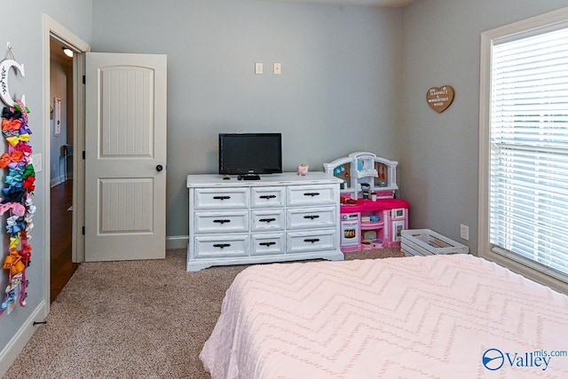 carpeted bedroom with multiple windows and baseboards