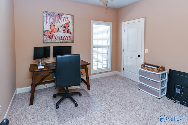 carpeted home office with baseboards and ceiling fan