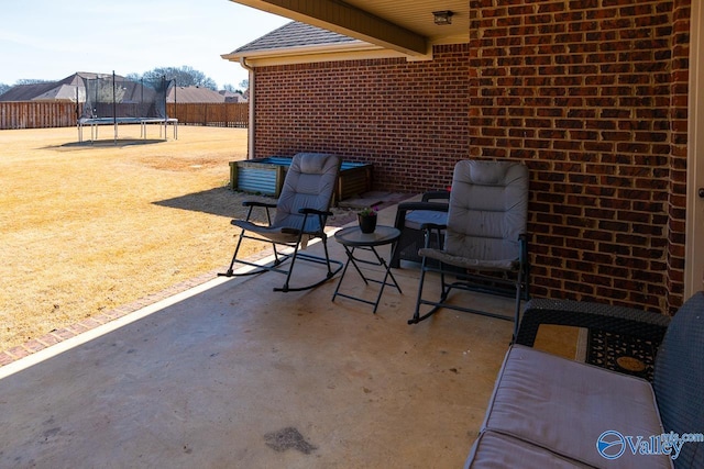 view of patio / terrace with a trampoline and fence