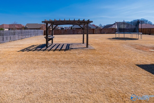 view of yard featuring a fenced backyard, a pergola, and a trampoline