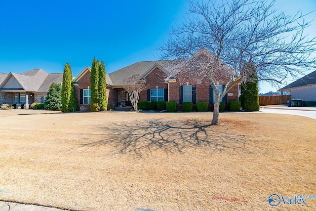 view of front of property featuring brick siding and fence