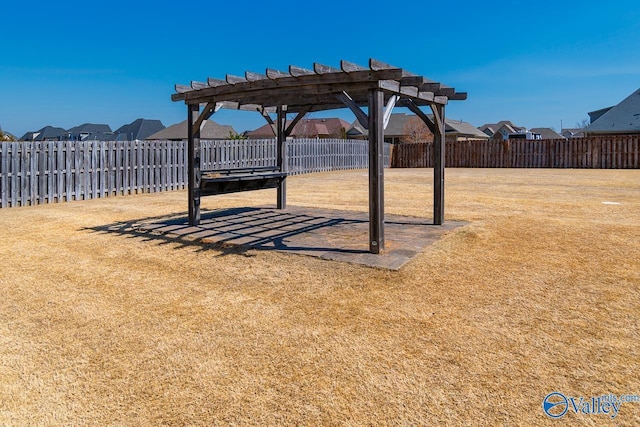 view of yard with fence, a pergola, and a residential view