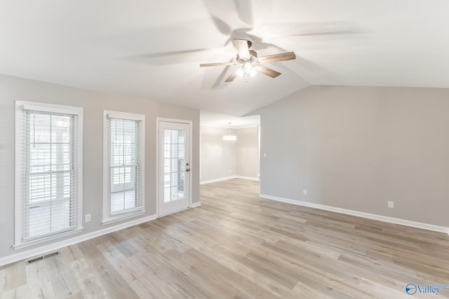 unfurnished living room with lofted ceiling, baseboards, visible vents, and light wood finished floors