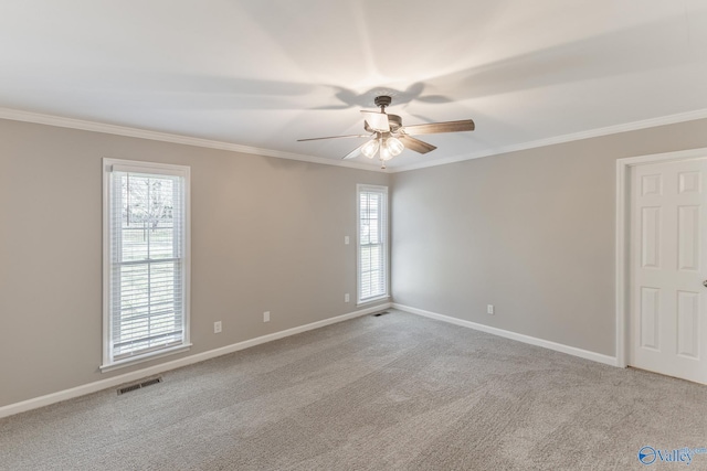 empty room featuring light carpet, baseboards, visible vents, and crown molding