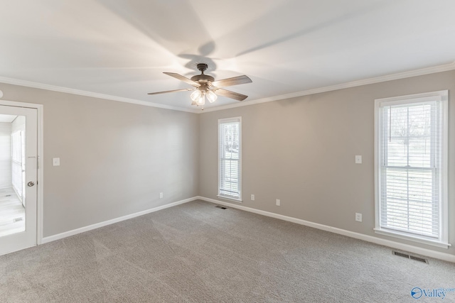 unfurnished room featuring carpet floors, ceiling fan, visible vents, and crown molding