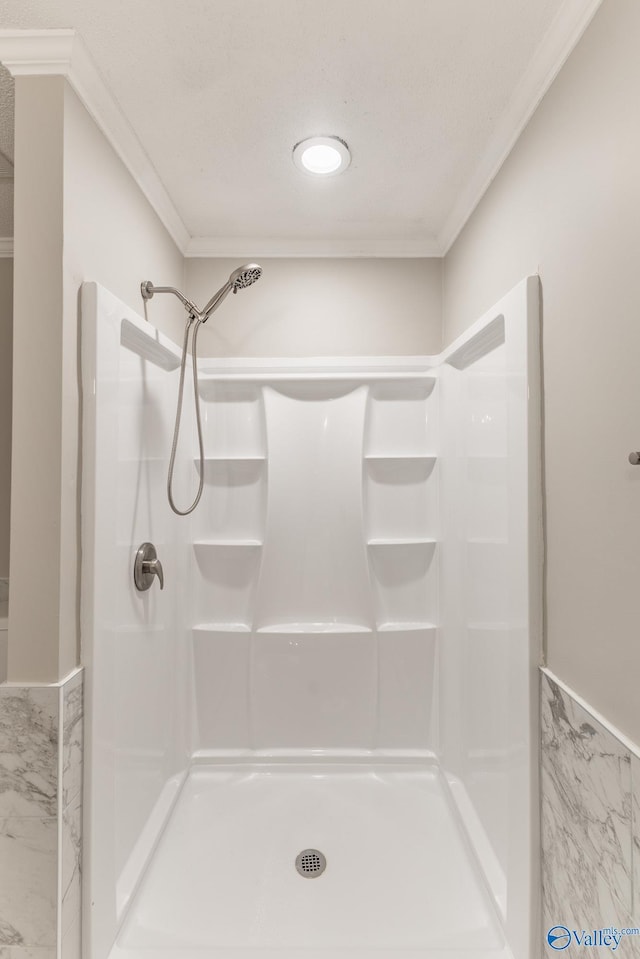 full bathroom with a shower stall and crown molding