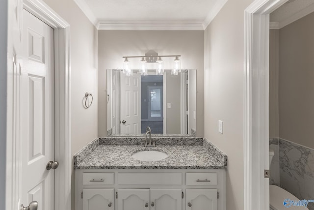 bathroom featuring toilet, ornamental molding, and vanity