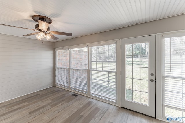 unfurnished sunroom featuring visible vents and a ceiling fan