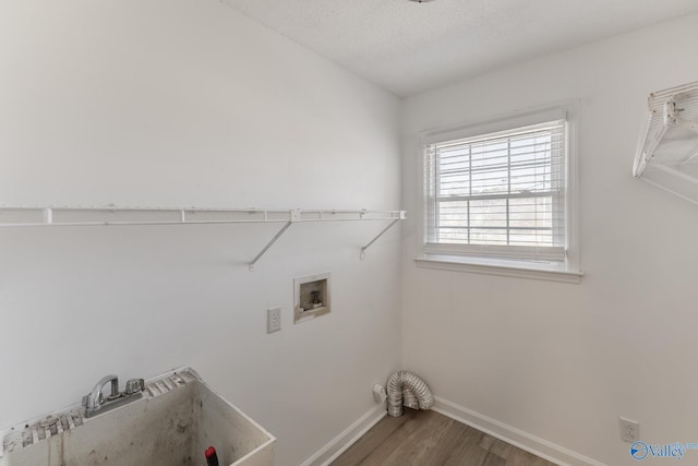 washroom featuring laundry area, baseboards, wood finished floors, hookup for a washing machine, and a sink