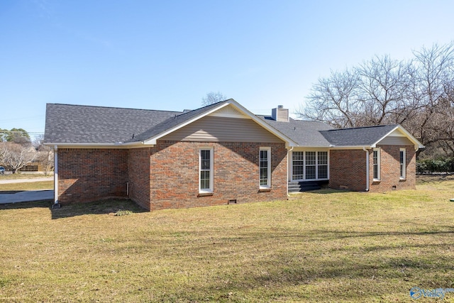 rear view of house with brick siding and a yard