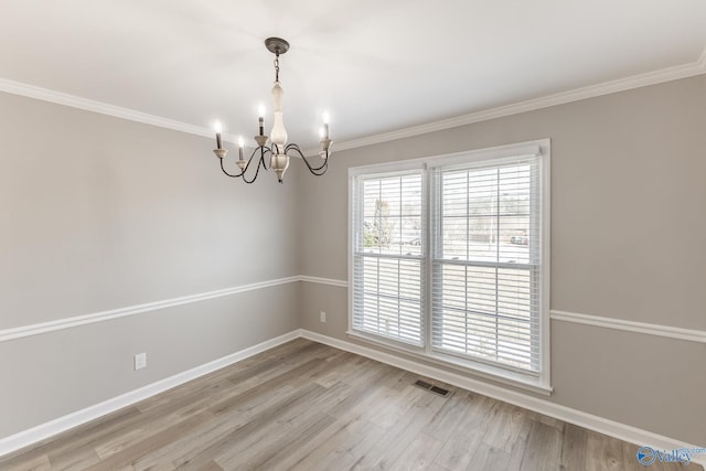 unfurnished room with ornamental molding, visible vents, baseboards, and wood finished floors