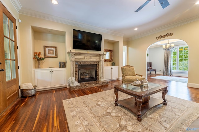 1805 Sibert Dr, Glencoe, AL 35905 - living room featuring dark wood-type flooring, arched walkways, a ceiling fan, crown molding, and a premium fireplace