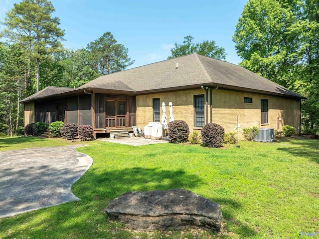 1805 Sibert Dr, Glencoe, AL 35905 - rear view of house featuring a sunroom, central air condition unit, a yard, a shingled roof, and a patio