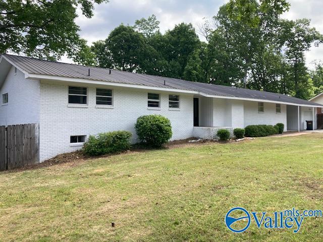 625 S Mountain Dr E, Trinity, AL 35673 - rear view of house with fence, an attached garage, brick siding, a lawn, and metal roof