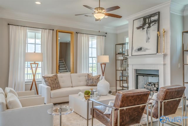 living room with a wealth of natural light, crown molding, and ceiling fan