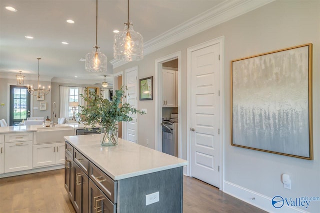 kitchen featuring dark hardwood / wood-style flooring, crown molding, white cabinets, and pendant lighting