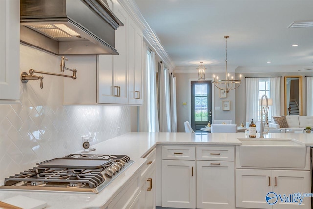 kitchen featuring stainless steel gas cooktop, white cabinetry, tasteful backsplash, and sink