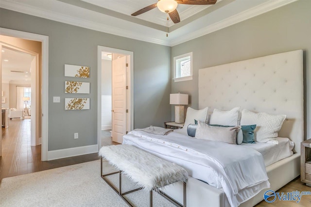 bedroom featuring ceiling fan, ornamental molding, ensuite bathroom, and hardwood / wood-style floors