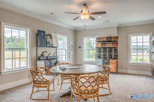 dining room with crown molding, light colored carpet, and ceiling fan