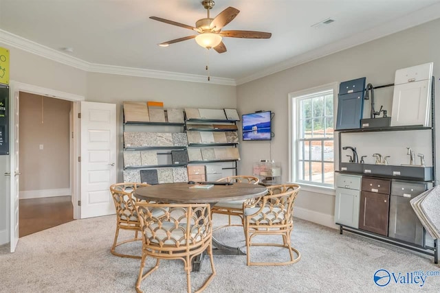 carpeted dining area with ornamental molding and ceiling fan