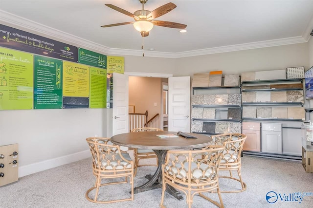 dining space featuring crown molding, light colored carpet, and ceiling fan