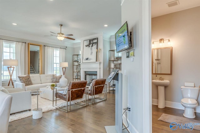 living room featuring ornamental molding, hardwood / wood-style flooring, and plenty of natural light