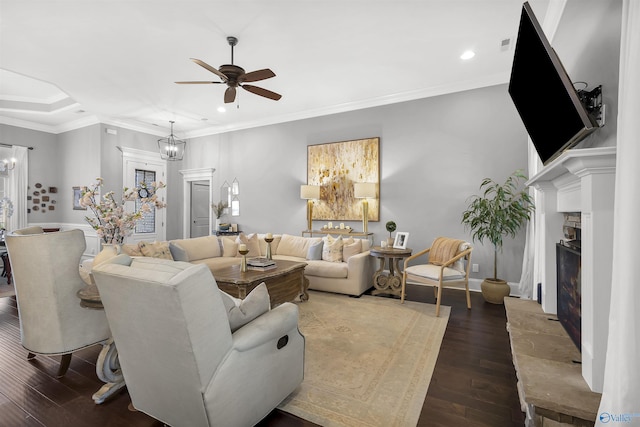 living room with recessed lighting, hardwood / wood-style flooring, ceiling fan with notable chandelier, and a fireplace