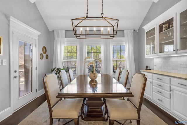 dining space featuring plenty of natural light, vaulted ceiling, and an inviting chandelier