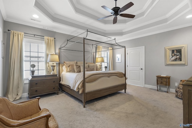 carpeted bedroom featuring a raised ceiling, ornamental molding, ceiling fan, and visible vents