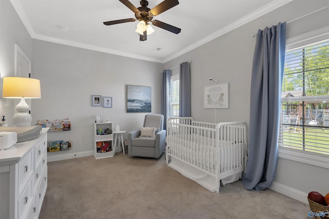 bedroom featuring crown molding, baseboards, a crib, and light carpet