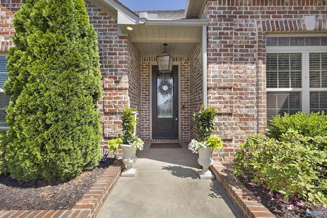 entrance to property featuring brick siding
