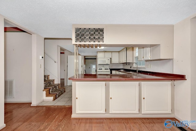 kitchen with light hardwood / wood-style flooring, white cabinets, white appliances, and sink