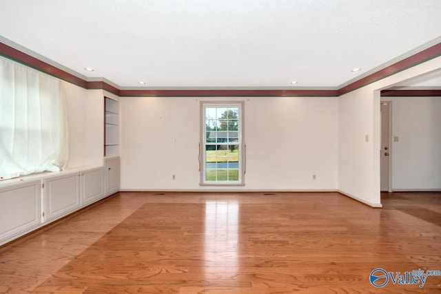 spare room with light hardwood / wood-style floors and ornamental molding