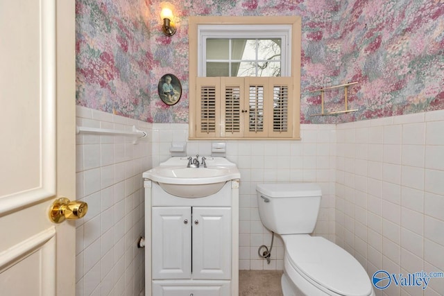 bathroom with vanity, toilet, and tile walls