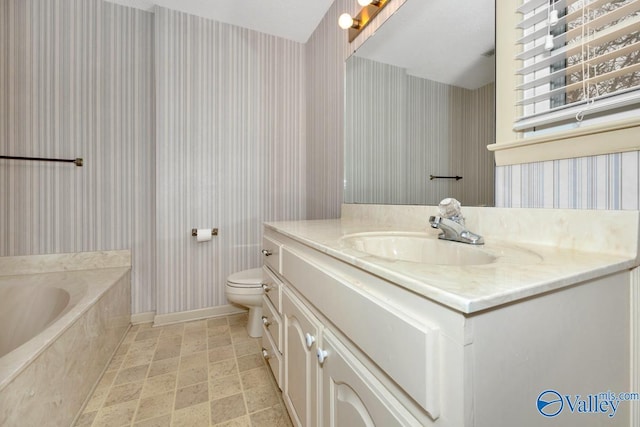 bathroom featuring vanity, a bath, and toilet