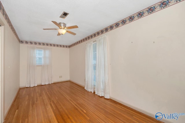 unfurnished room featuring ceiling fan, a textured ceiling, and hardwood / wood-style flooring