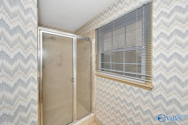 bathroom with a textured ceiling and walk in shower