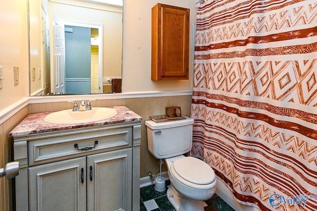 full bathroom with wainscoting, curtained shower, toilet, and vanity