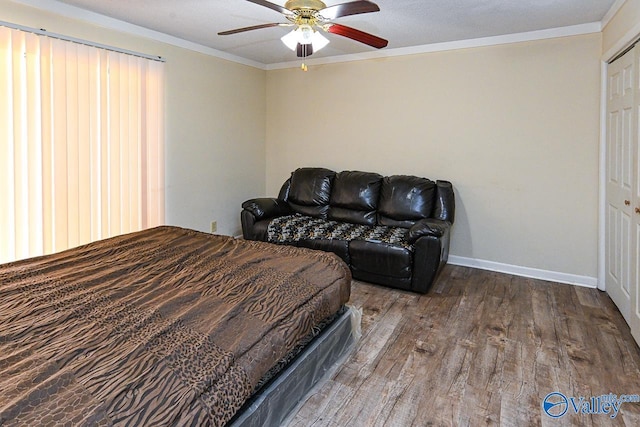 bedroom featuring hardwood / wood-style flooring, crown molding, baseboards, and ceiling fan