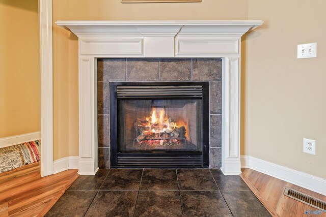 room details featuring wood-type flooring and a tile fireplace