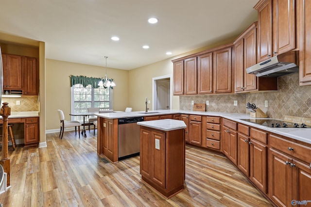 kitchen featuring a chandelier, a kitchen island, kitchen peninsula, stainless steel dishwasher, and light hardwood / wood-style floors