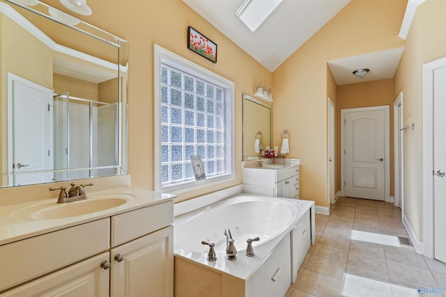 bathroom with tile patterned floors, separate shower and tub, vaulted ceiling with skylight, and vanity