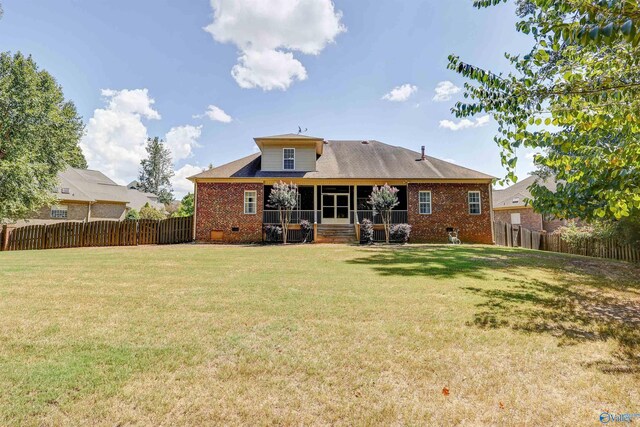 rear view of house with a lawn and a sunroom