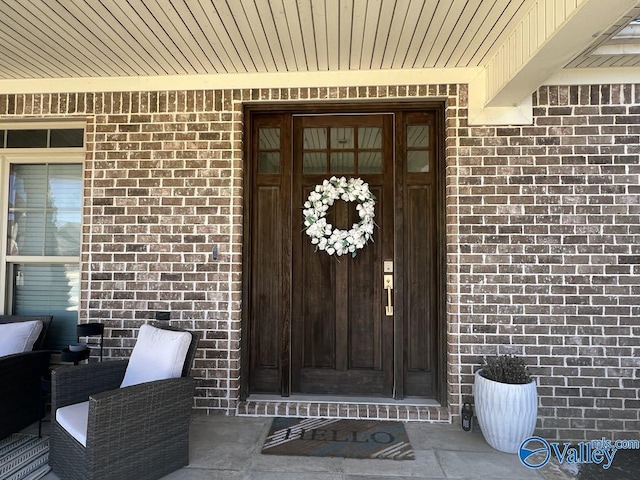 doorway to property featuring brick siding