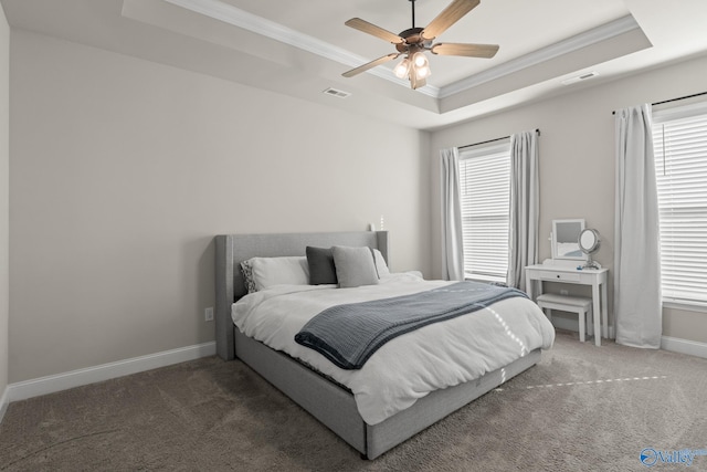 carpeted bedroom featuring ceiling fan, crown molding, and a tray ceiling