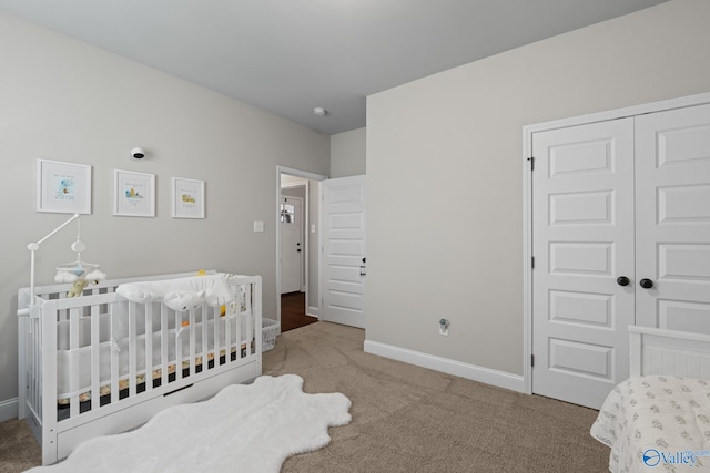 carpeted bedroom with a nursery area and a closet