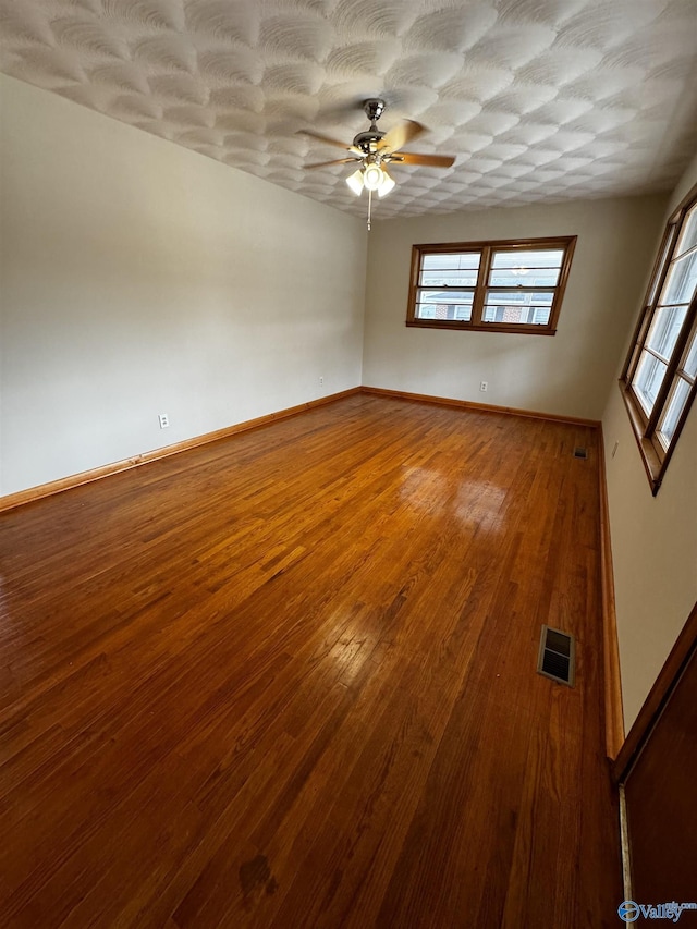 unfurnished room with ceiling fan, hardwood / wood-style floors, and a textured ceiling