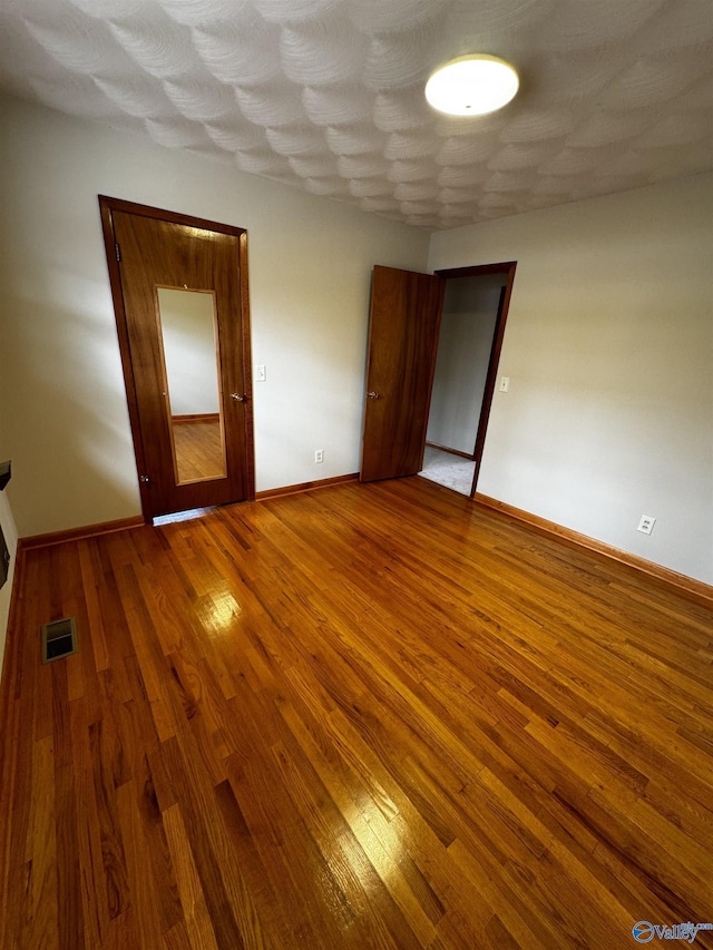 spare room featuring wood-type flooring